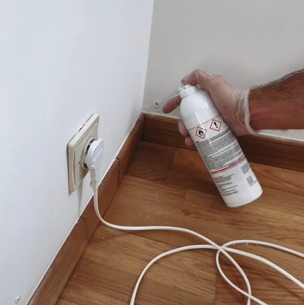 Injection de mousse rodenticide de contact dans un vide de cloison, canule dans le perçage, appartement Romainville
