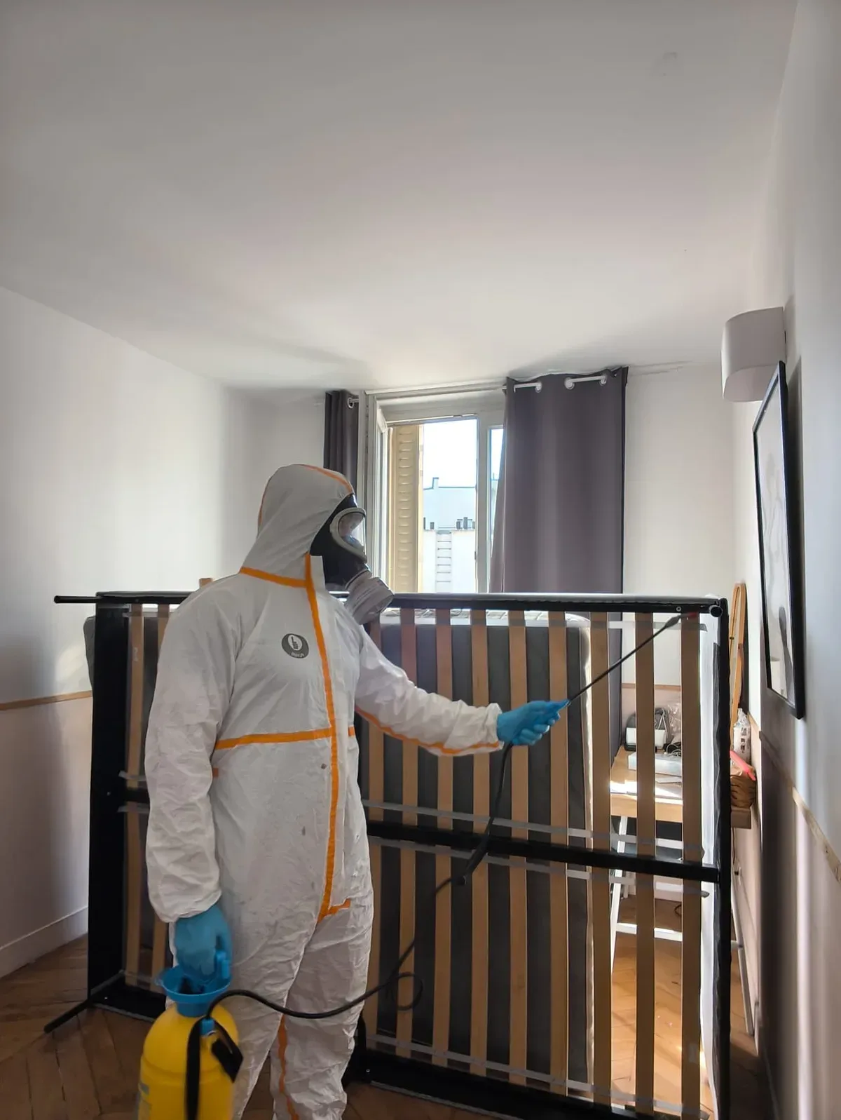 Pulvérisation d'insecticide sur un sommier à lattes lors d'un traitement punaises de lit à Paris 2e, quartier Bourse